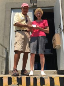 Jean D. receiving a complimentary OILH Xmas ornament from E. Gifford Stack FOIL board member and lighthouse tour coordinator after her successful climb as the most senior female climber